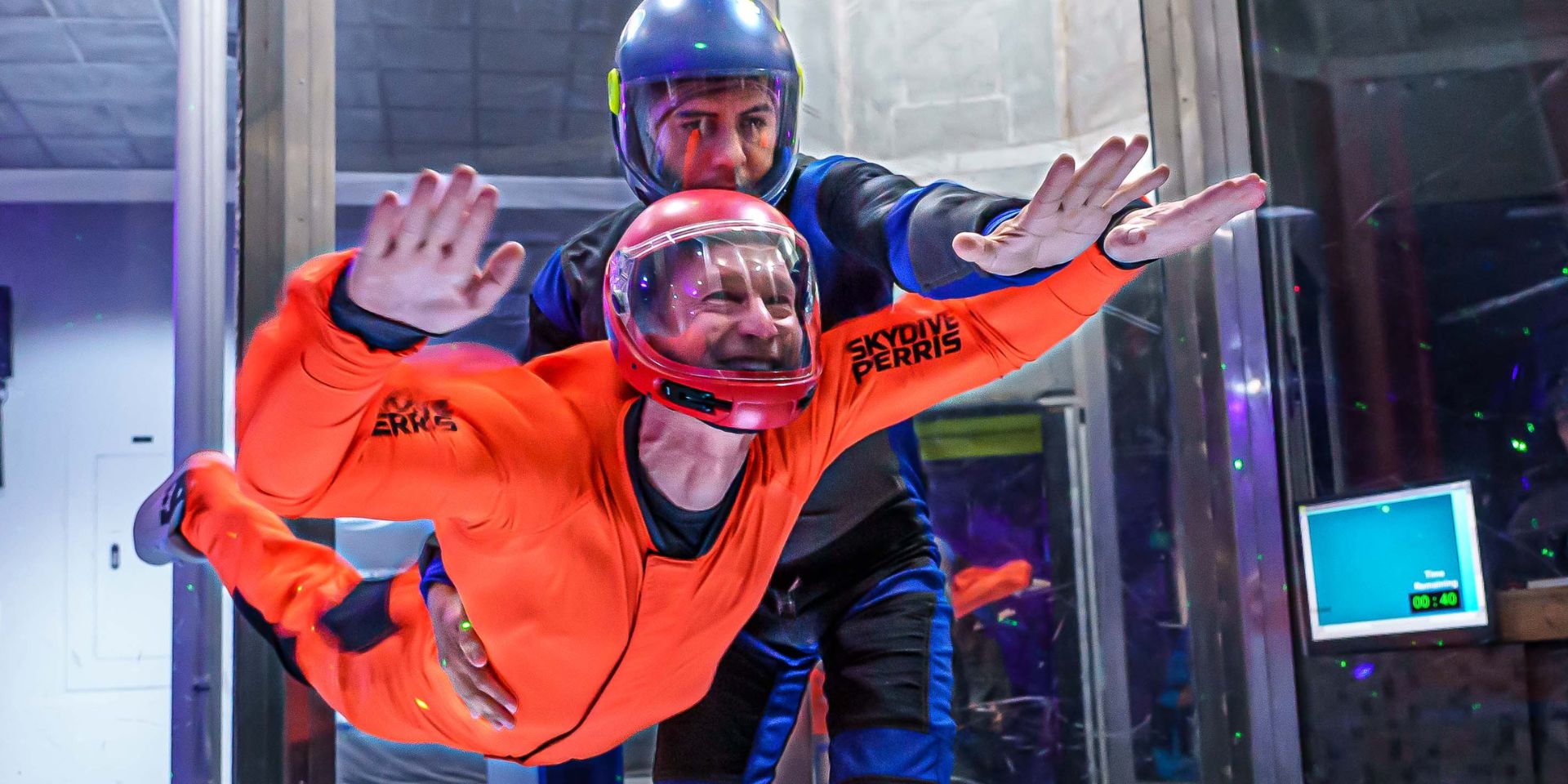 Instructor and student flying in indoor skydiving tunnel