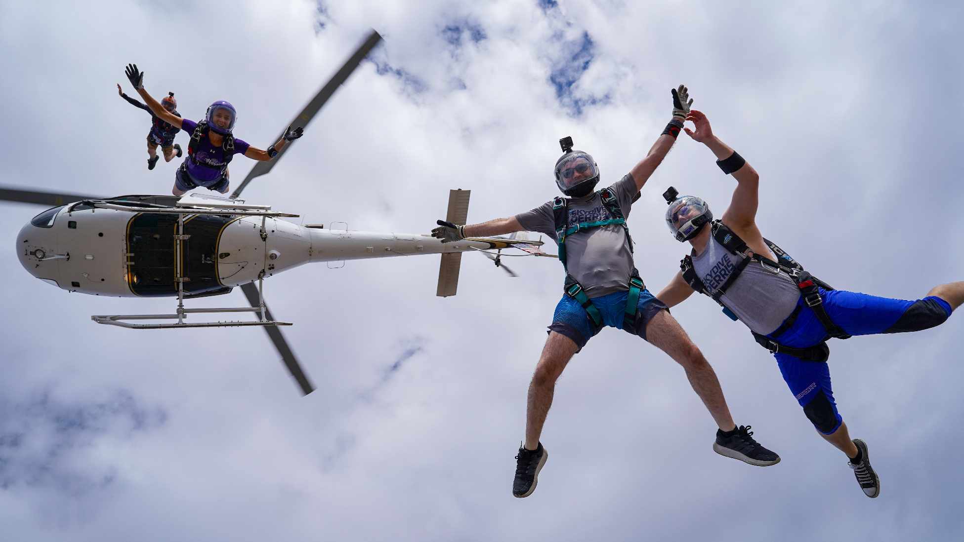 experienced skydivers exit helicopter and enter into freefall