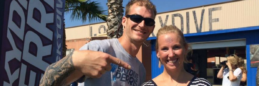 woman holds skydiving license in front of Perris skydiving school